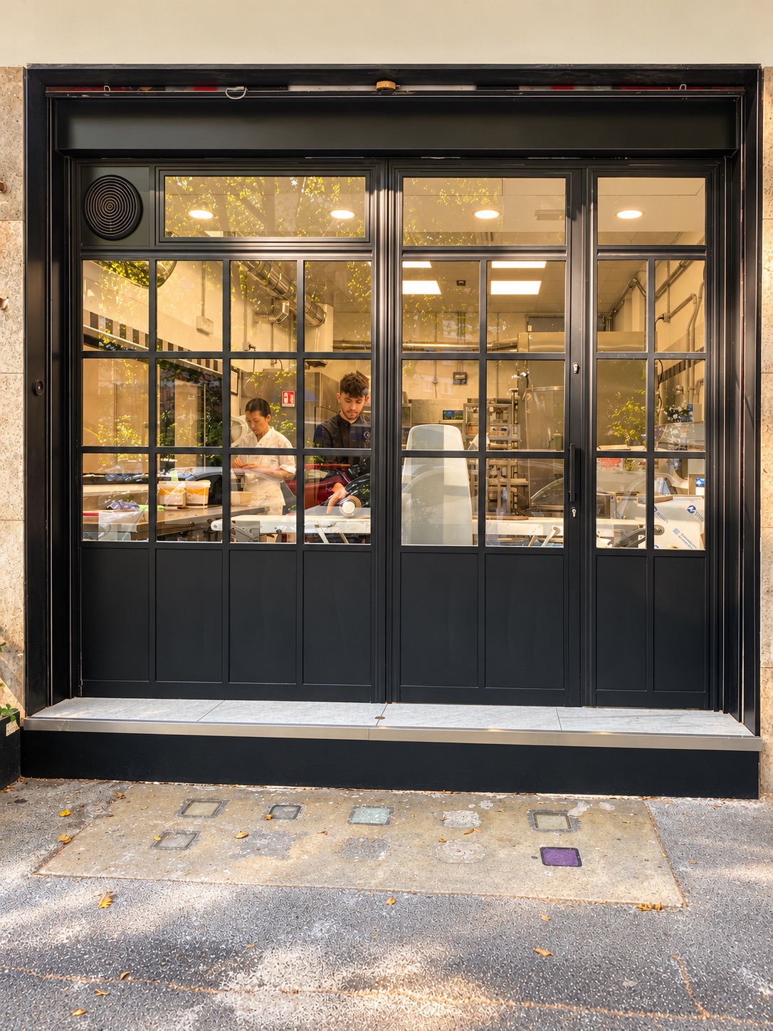 Pastry chefs working in Nero Vaniglia's lab, seen through the glass front from the street