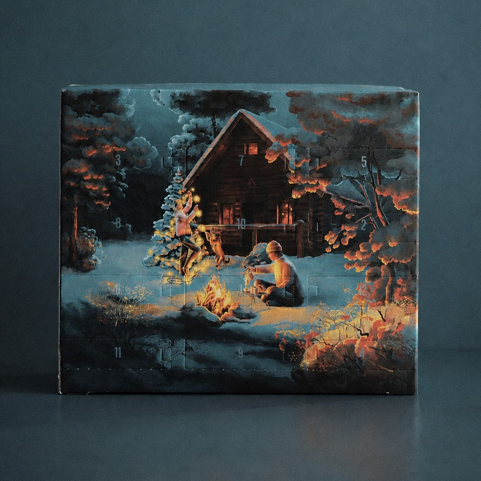 The Barn's 2026 advent calendar box, illustrated with a snowy forest cabin, a campfire and a lit Christmas tree, with numbered doors