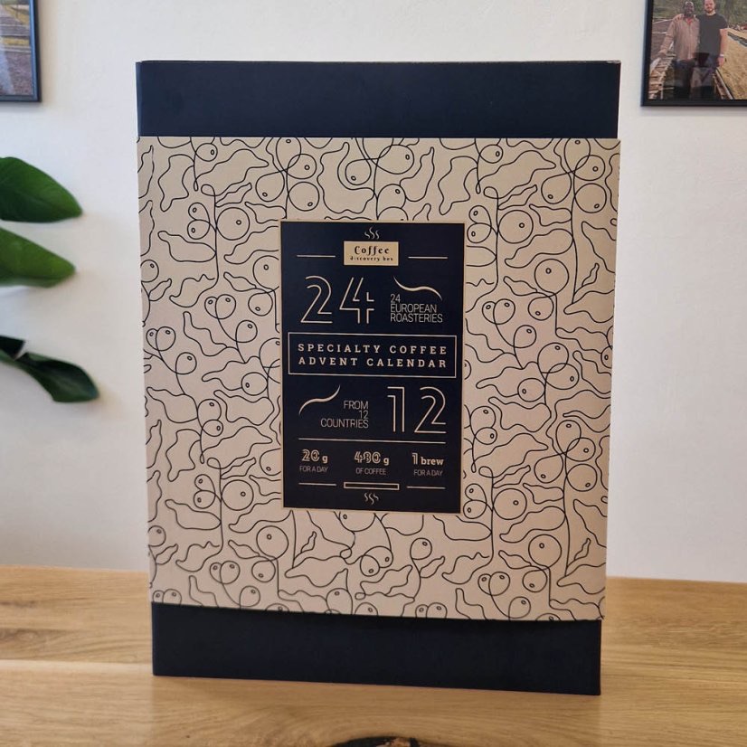 The Roses specialty coffee advent calendar, a navy and cream box reading 24 European roasteries from 12 countries, standing on a wooden table
